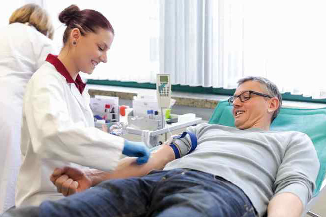 Das Bild zeigt einen Blutspender während ihm Blut abgenommen wird.