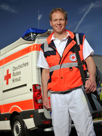 Der BRK-Rettungsdienst ist schnell vor Ort Ein Mitarbeiter des Rettungsdienstes vor einem Rettungswagen.