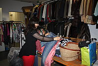 Bild zeigt Frau vor einer Auswahl an Second-Hand-Mode
