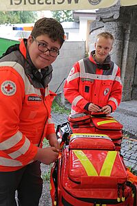 Das Fotos zeigt zwei ehrenamtliche Helfer im Sanitätsdienst mit Notfallrucksack