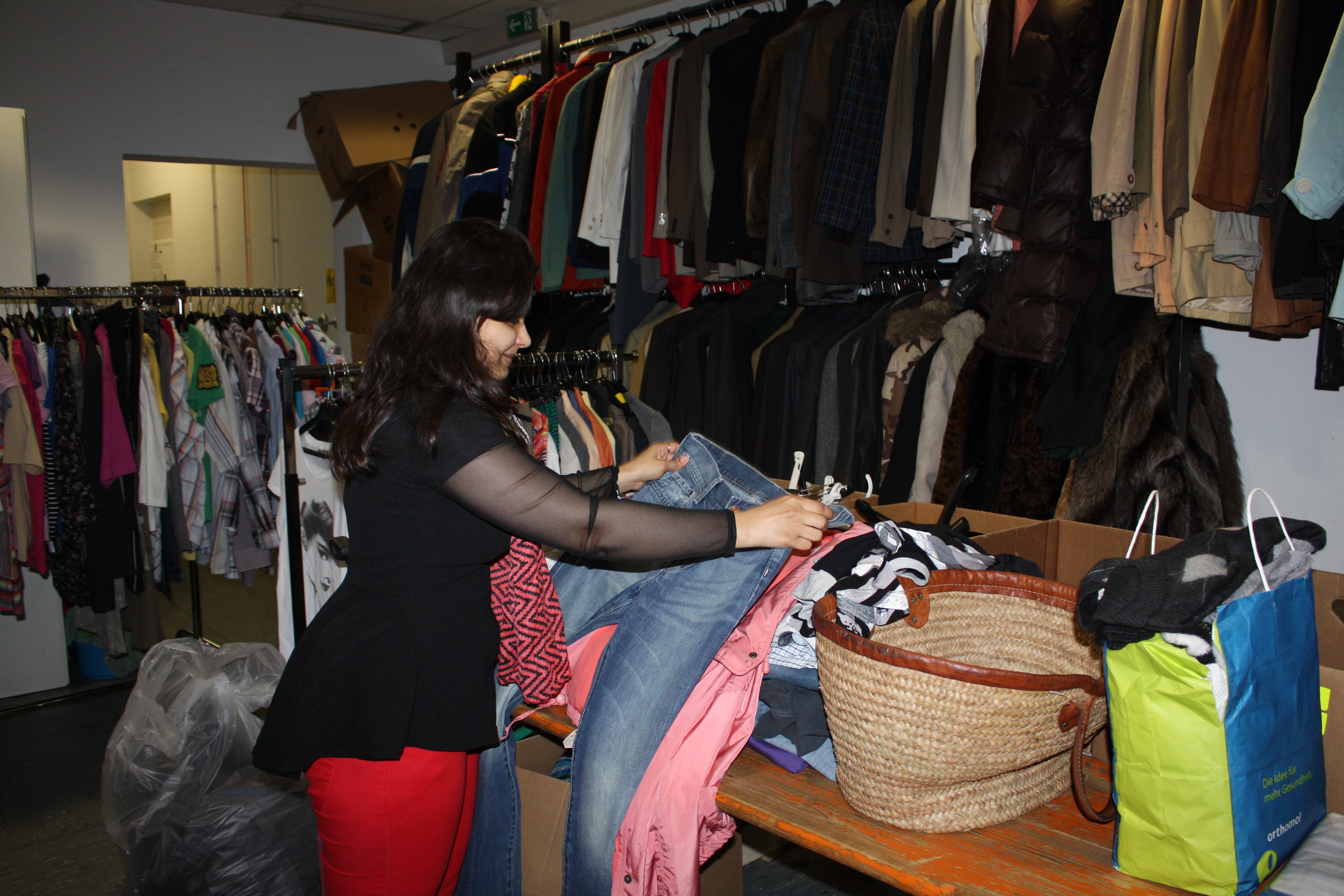 Bild zeigt Frau vor einer Auswahl an Second-Hand-Mode