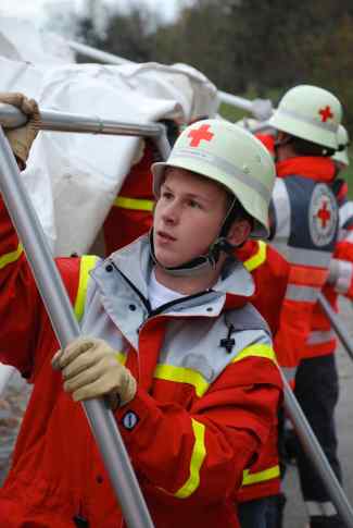 Das Bild zeigt einen Jungen in Rot-Kreuz-Kleidung.