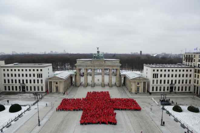 Rotkreuz-Helfer bilden ein Rotes Kreuz vor dem Brandenburger Tor in Berlin.