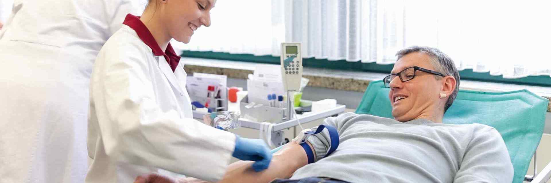 Das Bild zeigt einen Blutspender, während ihm Blut abgenommen wird.